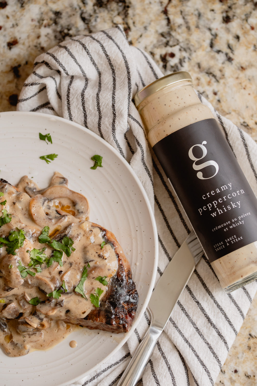 Bottle of Gourmet Inspirations Creamy Peppercorn Whisky Steak Sauce – rich, thick sauce with a hint of pepper heat.